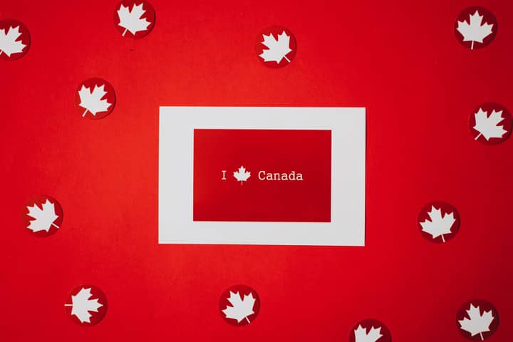 Red and white Canadian flag theme with maple leaves celebrating Canada Day.