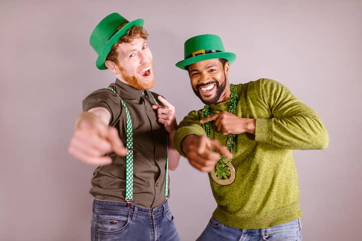 Two friends celebrating St. Patrick's Day with green hats and accessories, enjoying a fun moment.