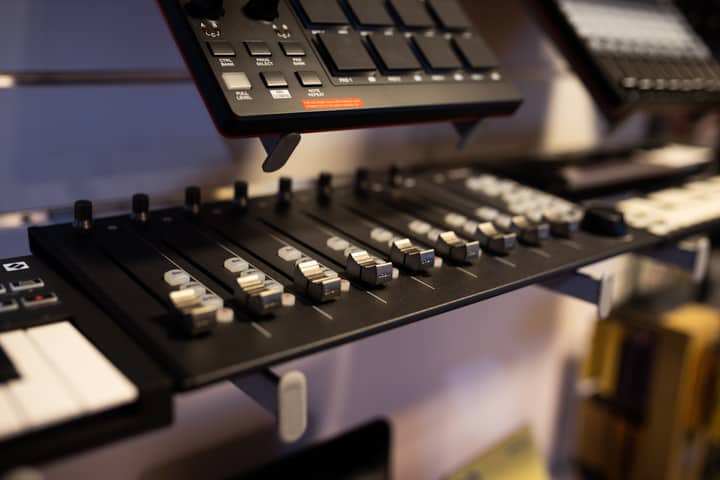 A close-up view of professional audio mixing equipment in a studio setting.