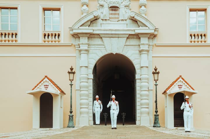 Guards standing at the entrance of the Prince's Palace, Monaco. Elegant architecture and ceremonial uniforms.