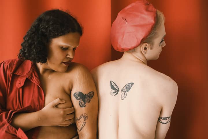 Stylized indoor studio portrait celebrating diversity and body art.