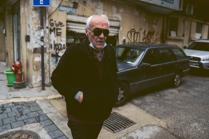Senior man wearing sunglasses walks through an urban street in Beirut, Lebanon.