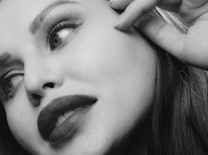 Detailed black and white portrait focusing on a woman's expressive eyes and lips.