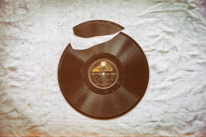 A close-up of a broken vintage vinyl record with nostalgic retro vibes on fabric.