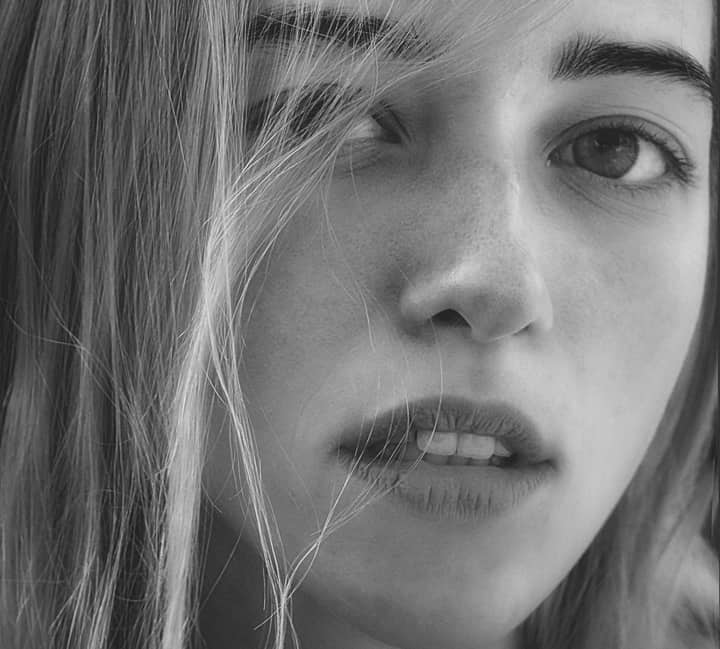 A captivating black and white close-up portrait of a woman looking at the camera.