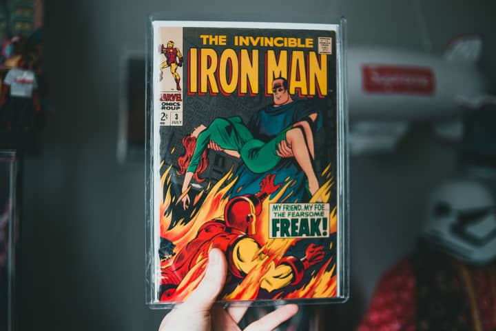 Vintage Iron Man comic book held by hand, showcasing iconic superhero imagery.