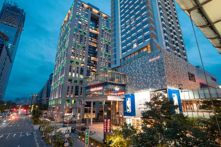 Vibrant cityscape featuring illuminated skyscrapers in downtown Taipei during twilight.