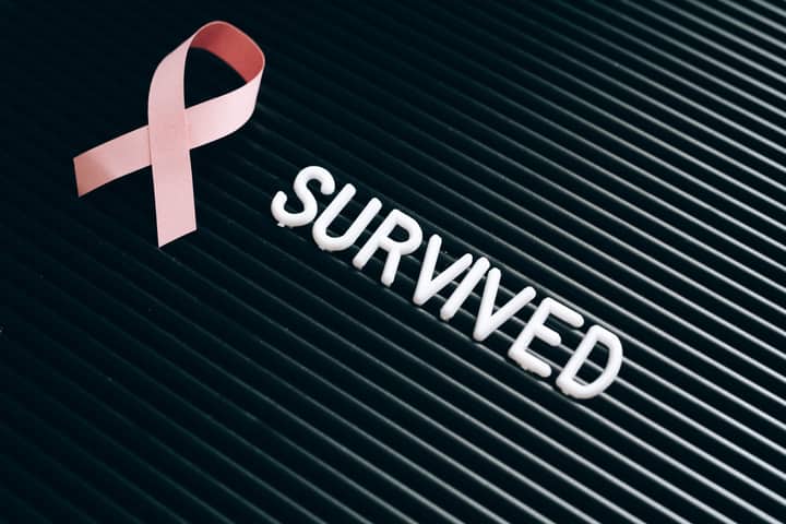 Pink ribbon and 'survived' text symbolize breast cancer awareness and survivorship.