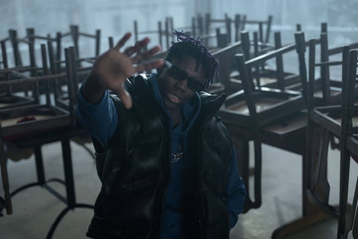A fashionable man in a puffer vest and sunglasses posing indoors. Captured with Canon EOS R.