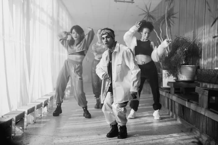 Energetic group of dancers performing hip hop in a stylish indoor setting.