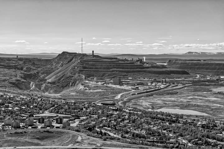 Monochrome aerial view of Kiruna mine, showcasing industrial and natural landscapes.