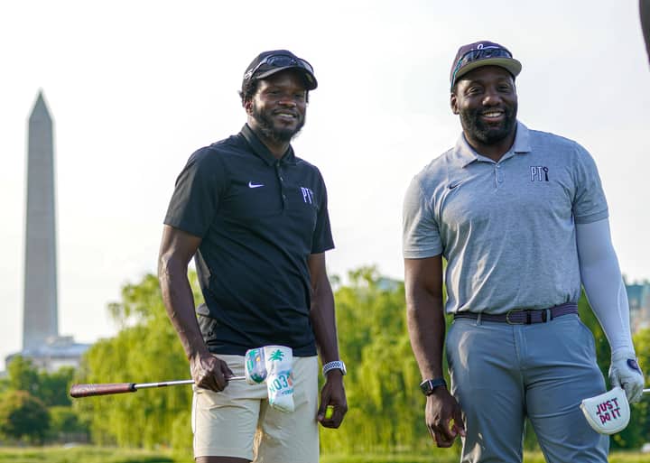 Two gentlemen enjoying a day of golf with the Washington Monument in the background.