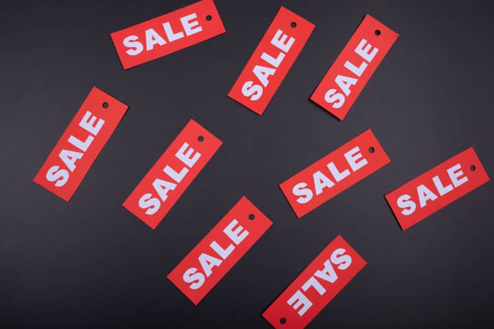 Top view of red sale tags on a black surface, perfect for marketing promotions.