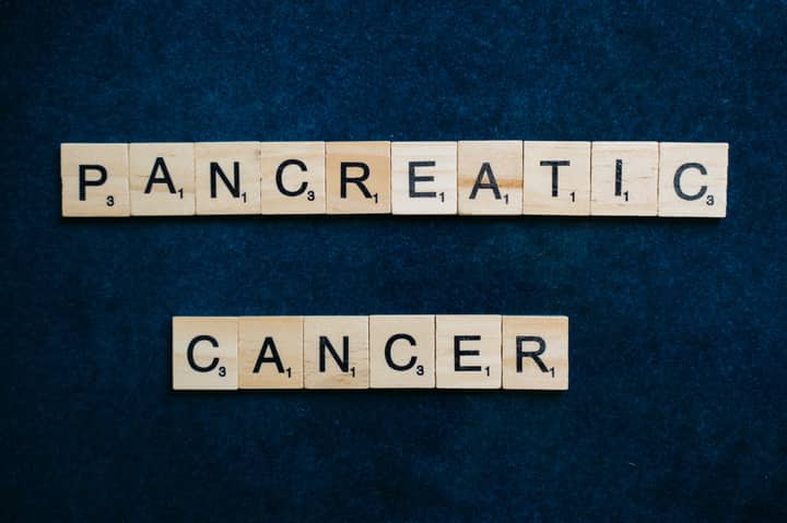 Wooden tiles spelling 'Pancreatic Cancer' on a textured blue background.