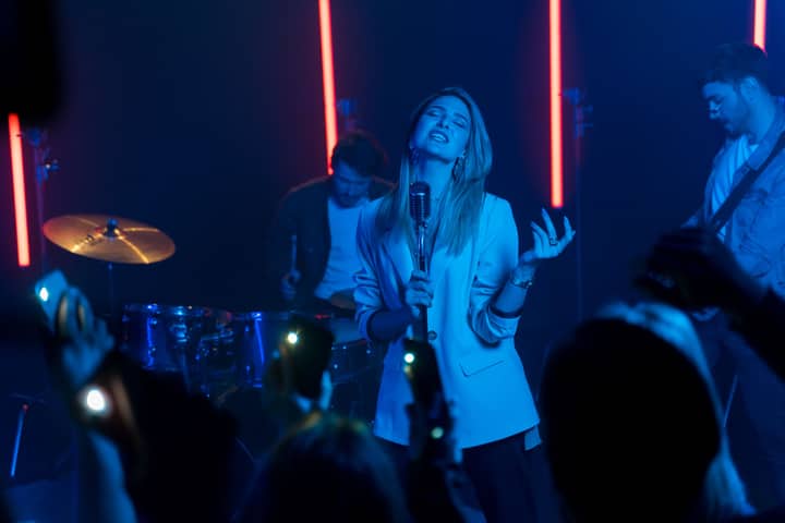 A captivating live concert performance by a female vocalist with neon lighting effects.