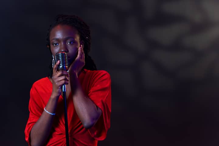 A captivating image of an African American woman singing passionately into a vintage microphone.