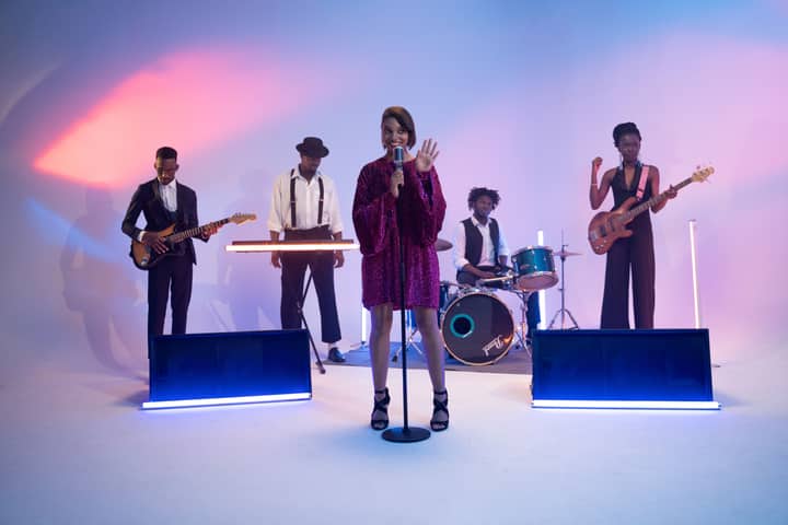 Vibrant live band with diverse musicians performing energetically on stage.