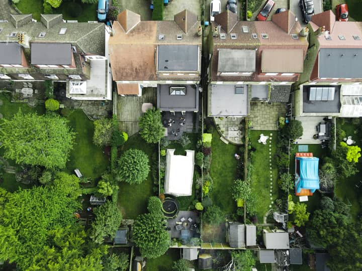 Aerial view of suburban gardens and homes in the green area of South England.