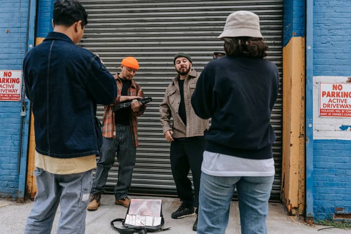 A group of diverse adults posing with musical instruments outdoors.