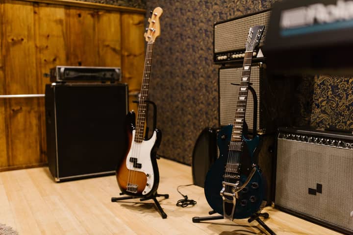 A cozy music studio featuring electric guitars and amplifiers, ideal for music production.