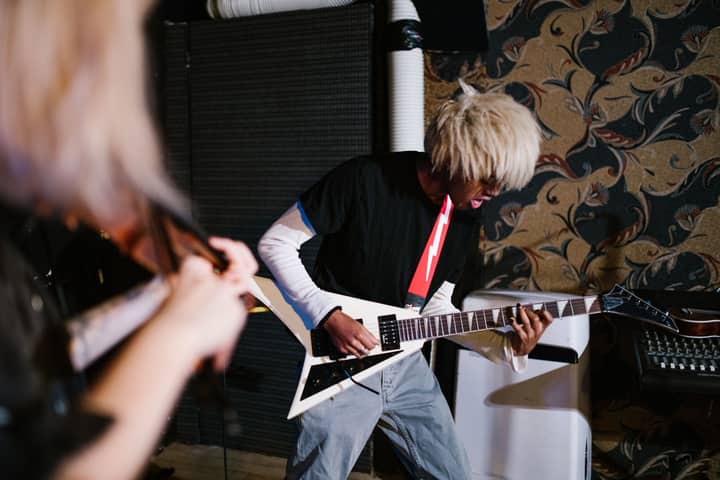 A person practicing electric guitar skillfully in an indoor music setting.