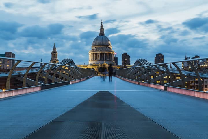 A striking shot of St Paul's Cathedral in London taken from Millennium Bridge at dusk, highlighting modern architecture.