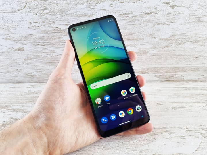 Close-up of a hand holding a smartphone with vibrant screen indoors, bright and clear display.