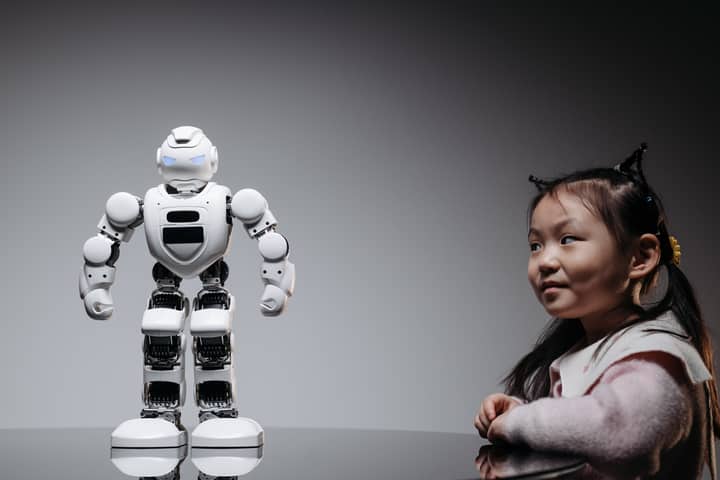 Young Asian girl interacts with a high-tech toy robot, showcasing innovation and curiosity.
