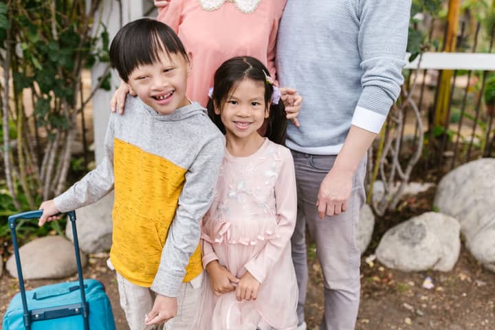Joyful Asian family with smiling children enjoying a day outdoors, showcasing warmth and togetherness.