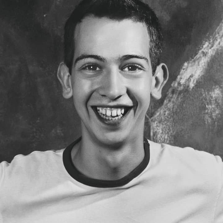 Energetic black and white portrait of a happy young man with a joyful smile.