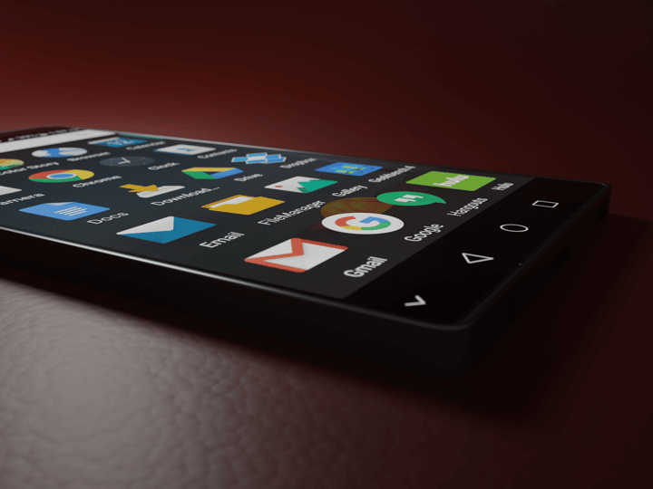 Close-up of a smartphone displaying various app icons in a low-light setting.