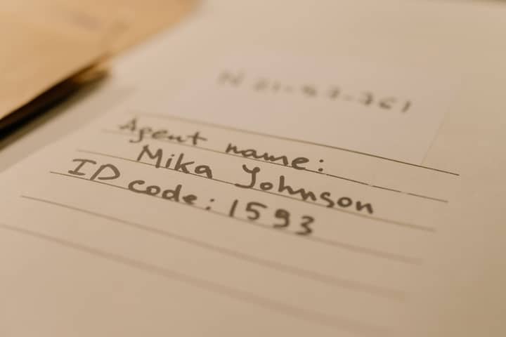 Handwritten document with agent name and ID code, showcasing personal handwritten text.