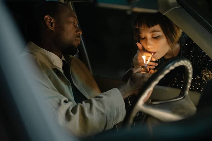 Two individuals sharing a moment inside a car at night, emphasizing companionship.