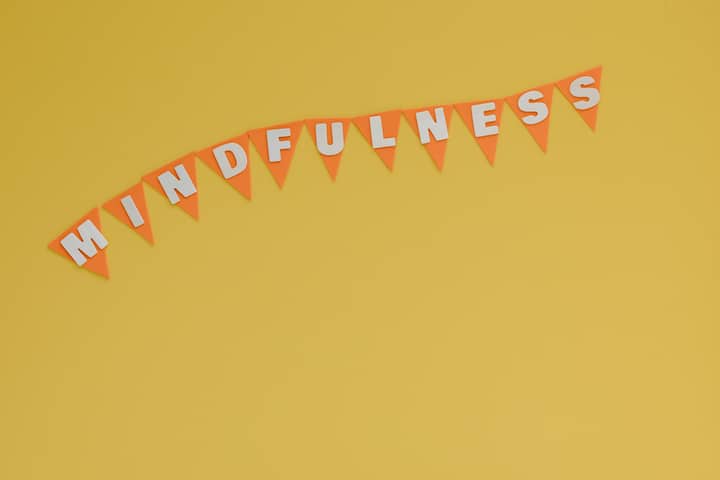 Banner with 'Mindfulness' on a bright yellow background, symbolizing calm and focus.