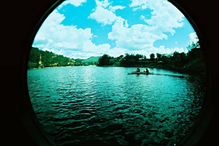 Kayaking on a serene lake surrounded by lush greenery in Ferreira do Zêzere, Portugal.