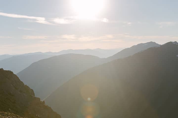 Captivating view of a misty mountain range bathed in soft sunlight at sunrise.