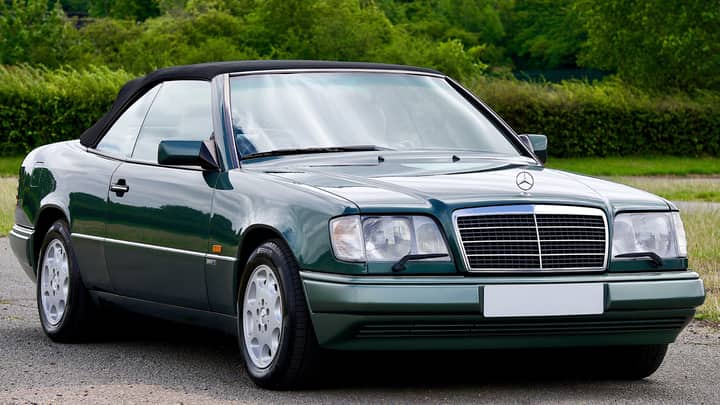 Vintage Mercedes Benz E320 convertible parked outdoors, exuding elegance and luxury.
