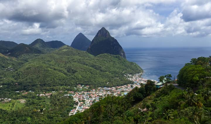 Discover the lush green landscapes and iconic Pitons of Soufriere, Saint Lucia from above.