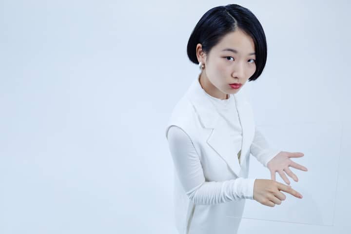 Asian woman interacting with transparent tablet in conceptual high angle view.