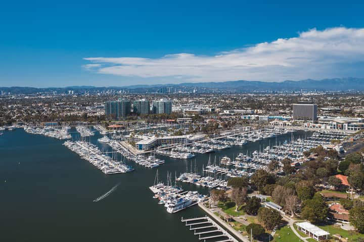 Stunning aerial photograph of Marina Del Rey showcasing boats and city skyline under a clear blue sky.