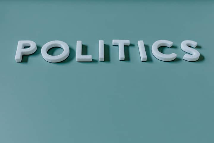 Close-up image of the word 'Politics' against a teal green background, highlighting political themes.