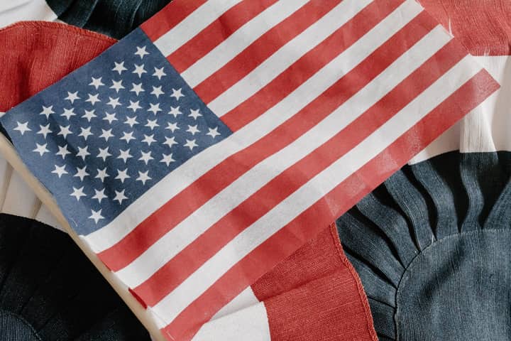 Close-up of the American flag on a textured fabric backdrop, symbolizing patriotism and national pride.