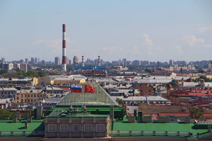 Breathtaking aerial view of urban Saint Petersburg skyline with chimneys and flags.