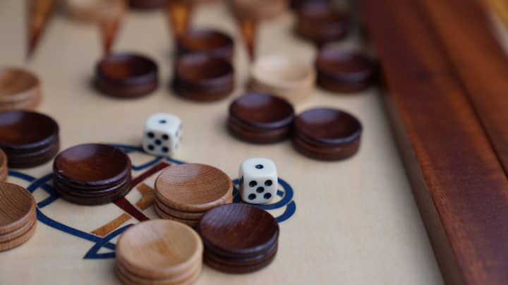Detailed shot of a backgammon board featuring wooden pieces and dice, perfect for game enthusiasts.