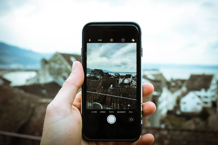 A smartphone captures the picturesque landscape of Rapperswil-Jona, Switzerland, highlighting modern technology.