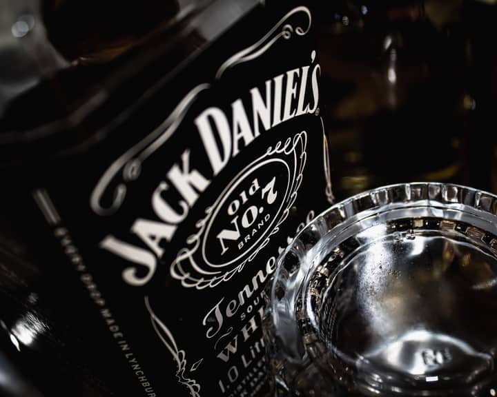 Detailed view of a Jack Daniel's whiskey bottle with glass, highlighting the brand's iconic label.