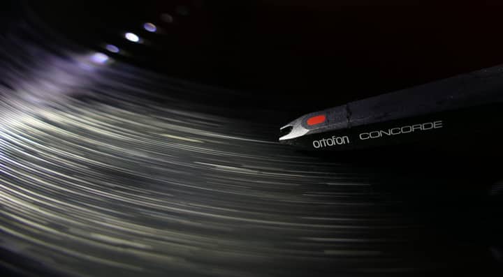 Dynamic close-up of an Ortofon Concorde needle playing a vinyl record, capturing the motion and vibe of music.