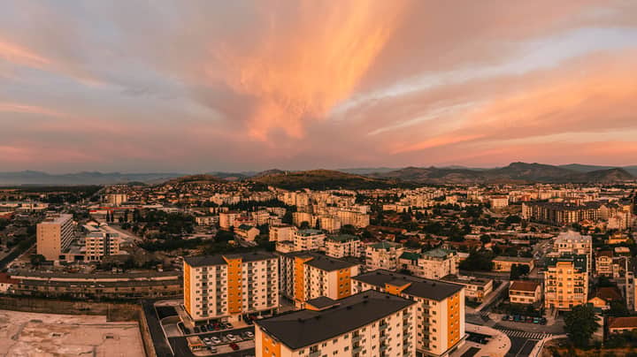 Scenic aerial view of Podgorica, Montenegro at sunset featuring vibrant skies and urban architecture.