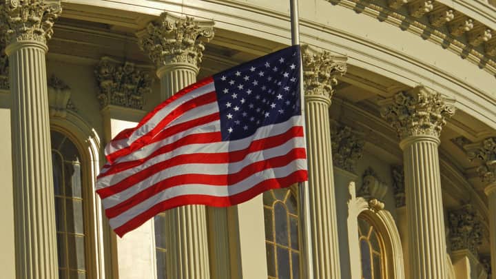 US flag waving outside the iconic US Capitol Building in Washington, DC.