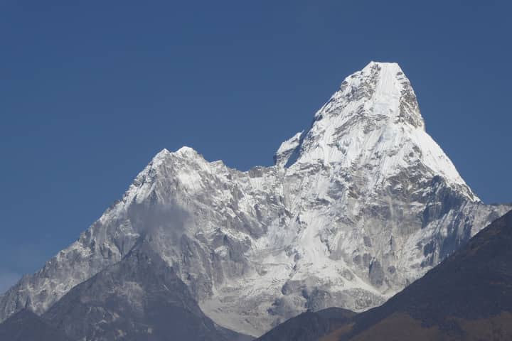 Majestic Mount Ama Dablam in Nepal, a striking snowy peak under clear blue skies.